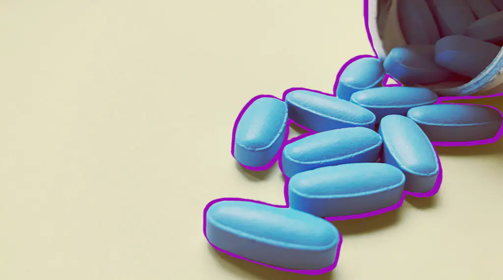 omprimidos azules esparcidos sobre una mesa, ilustrando medicación.