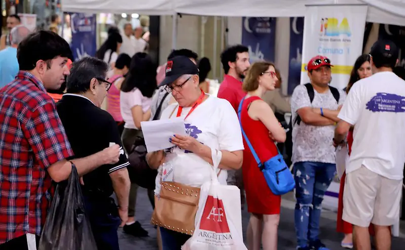 Persona revisa un folleto informativo durante una actividad en espacio público.