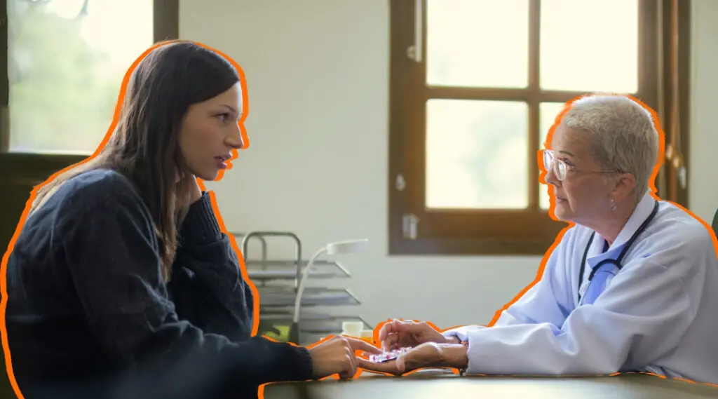 Profesional de salud conversa con una mujer durante consulta médica.