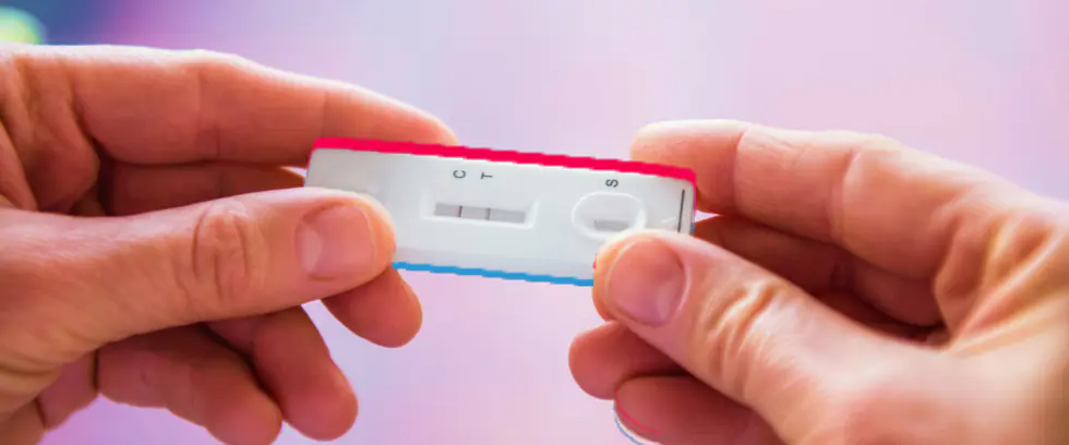 Manos sostienen un dispositivo de prueba rápida para detección de VIH.