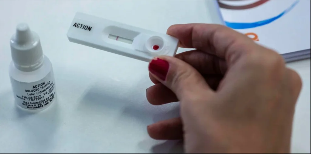 Persona sostiene dispositivo de prueba rápida de VIH durante el proceso de testeo.