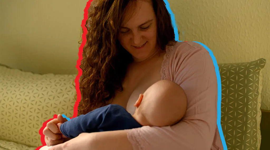 Madre amamanta a su bebé mientras lo sostiene en brazos.