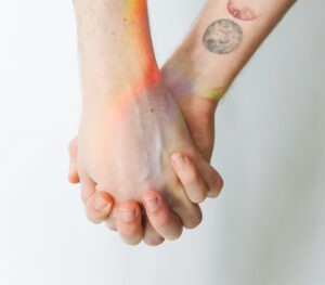 Dos personas se toman de las manos en señal de apoyo.