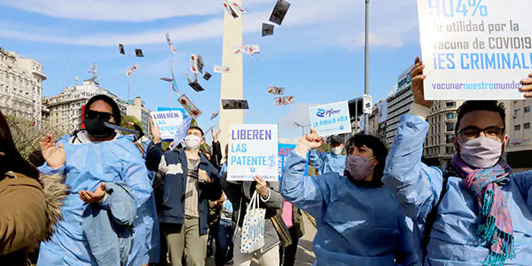 Integrantes de AHF Argentina participan en movilización por acceso a vacunas con carteles de la campaña VOW.
