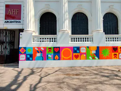 Fachada de AHF Argentina con mural colorido sobre prevención y diversidad en la parte inferior del edificio.