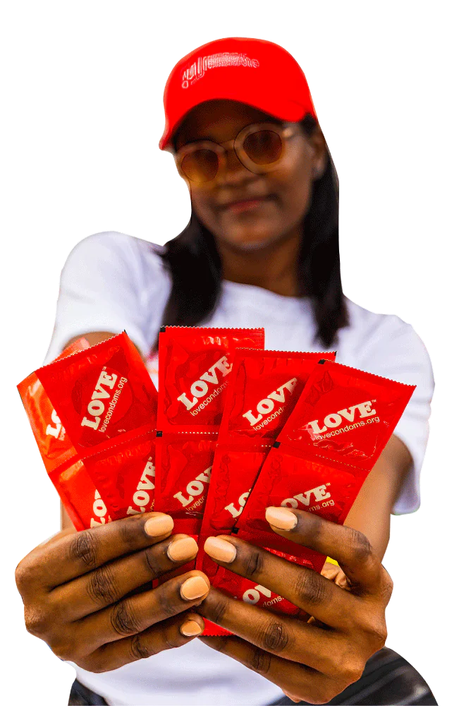 Mujer sostiene preservativos de la marca LOVE distribuidos por AHF Argentina para la prevención del VIH.